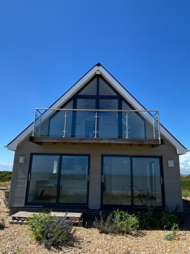 NormansBay Eastbourne East Sussex, windows fitting, new build house, wooden patio, double glazed windows, patio sliding doors, glass balustrade balcony.