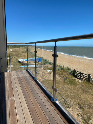 The composite balcony with a modern steel balustrade with a glazing system in sea view house on Eastbourne beach, East Sussex.