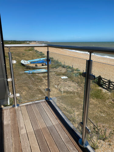 Sea view to the south from the composite balcony with a modern steel balustrade with a glazing system in Eastbourne beach.