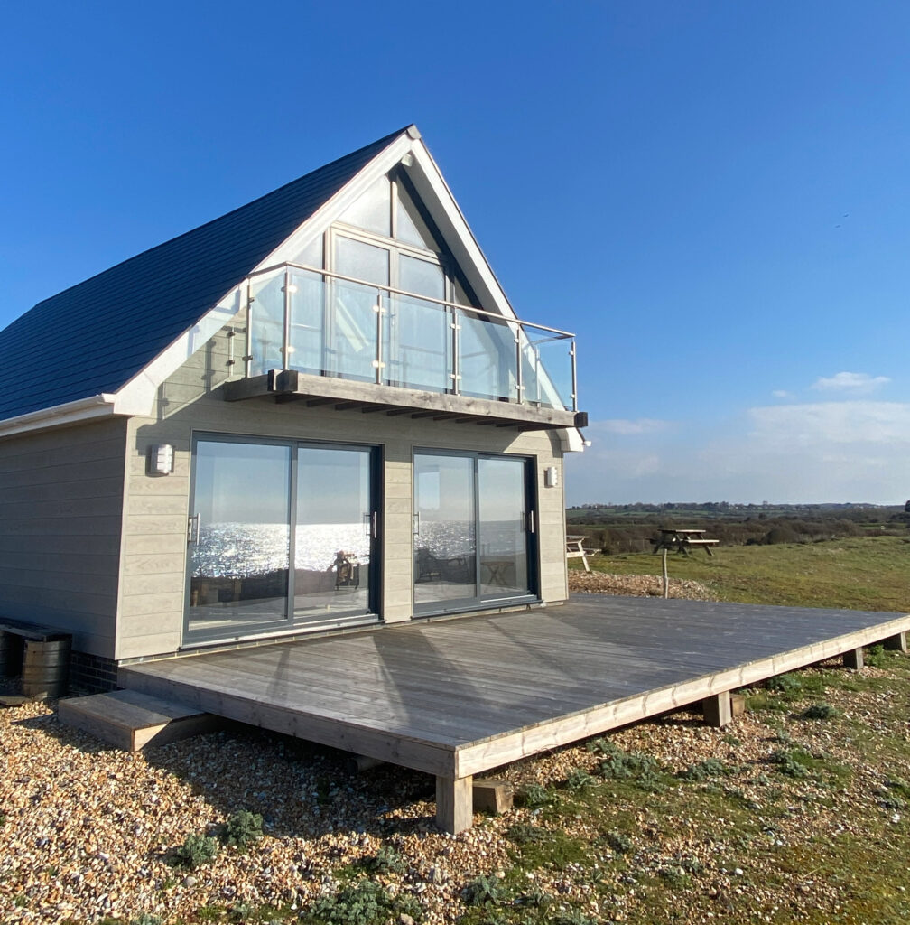 Sea-facing side of the newly built house in Eastbourne by River.ODP construction company, featuring wide sliding patio doors.