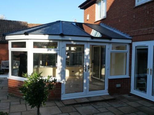 Conservatory with warm roof, white PVC windows & French doors. Conservatories built by River.ODP Building Company in Sussex.