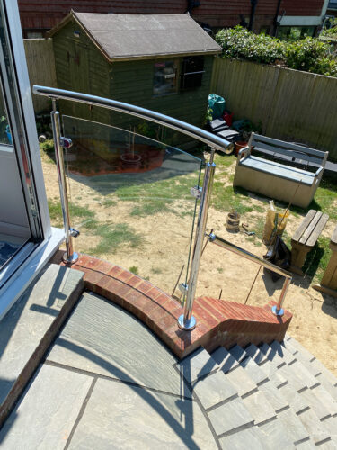 Glass panel installed between stainless steel balustrade posts in Hassocks by River.ODP, professional installers and builders.