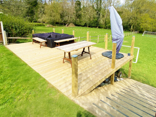 Sunny Wooden decking with timber posts and stainless steel wire rope balustrade built in Windlesham by River.ODP installation company.