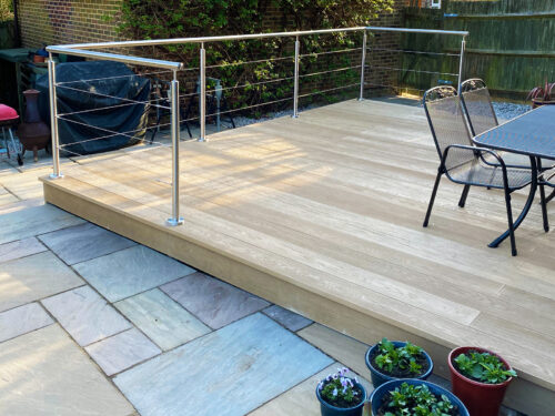 Modern stainless steel balustrade with a wired system installed on composite decking in Horam by Installation company River.ODP.
