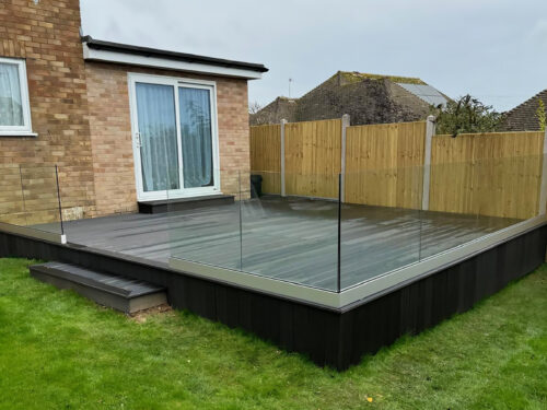 Frameless glass balustrade installed on black composite decking in Farnham by building company River.ODP.