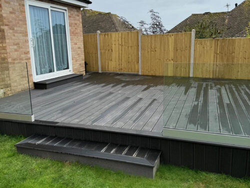Frameless glass balustrade mounted on black composite decking in Horley by installation company River.ODP.