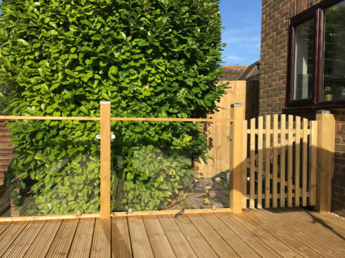 Wood and glass balustrade mounted on large timber decking in Ringmer by installation company River.ODP