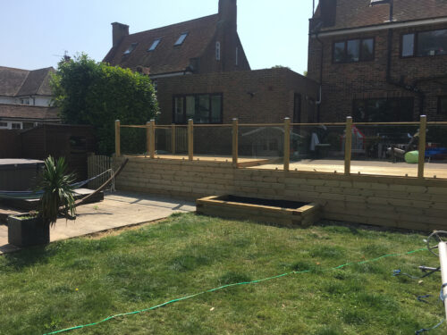 Wood and glass balustrade mounted on large timber decking in Portslade by Sea by installation company River.ODP