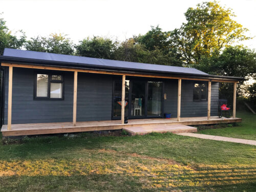 Farm style Garden house with veranda and Bi-folding patio doors build by construction company River.ODP in Surrey.