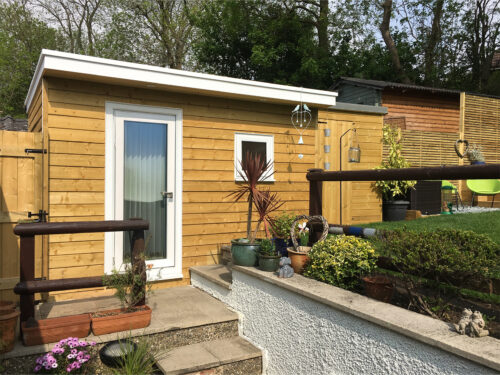 Insulated garden study room with wooden cladding and double UPVC windows built in Tadworth by River.ODP building company.