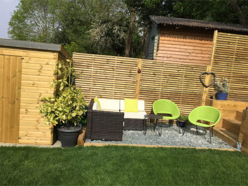 Garden sitting area at the side of study room with wooden cladding and double UPVC windows built in Tadworth by River.ODP building company.