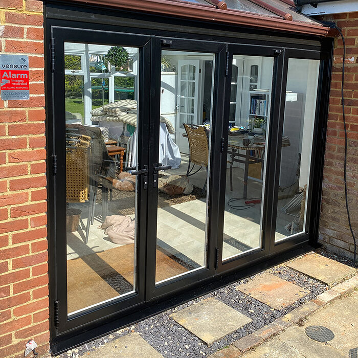New bi-folding aluminium black patio doors fitted by building company River.ODP