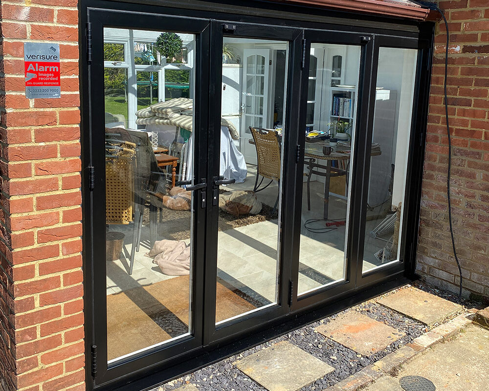 New bi-folding aluminium black patio doors fitted by building company River.ODP