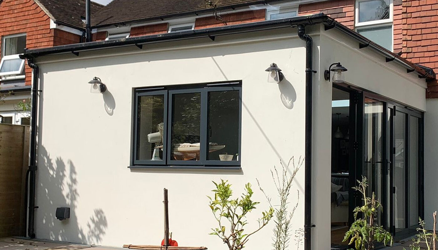 New modern extension with bi-folding graphite aluminium doors. Side view from the garden. by River ODP
