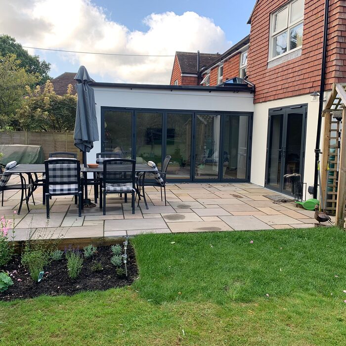 New modern house extension with bi-folding graphite aluminium doors. Front view from the garden. Built by contractor River ODP