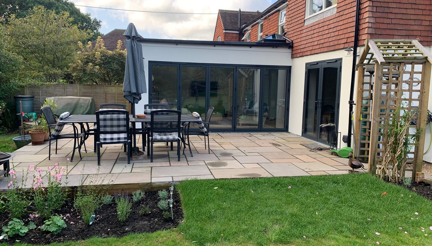 New modern house extension with bi-folding graphite aluminium doors. Front view from the garden. Built by contractor River ODP