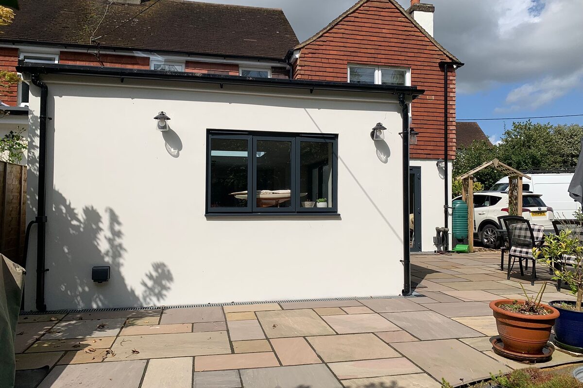 New modern extension with bi-folding graphite aluminium doors. Side view from the garden. by River ODP