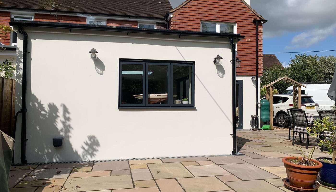 New modern extension with bi-folding graphite aluminium doors. Side view from the garden. by River ODP