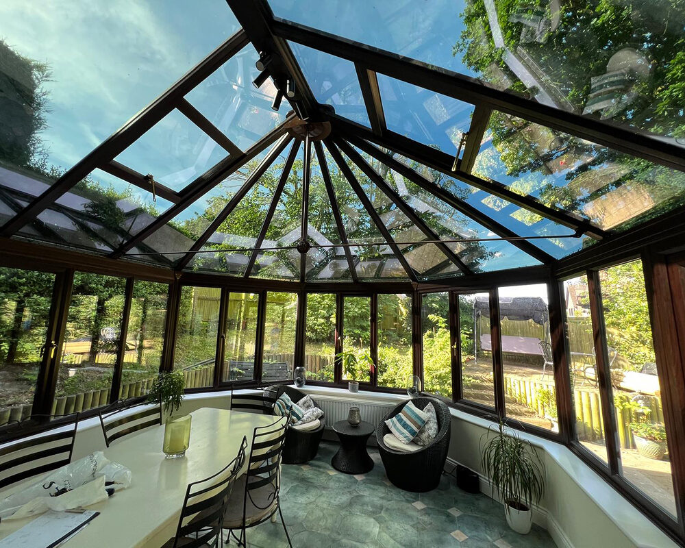 Black Victorian conservatory with a glass roof built in Bexhill by River.ODP, construction company.