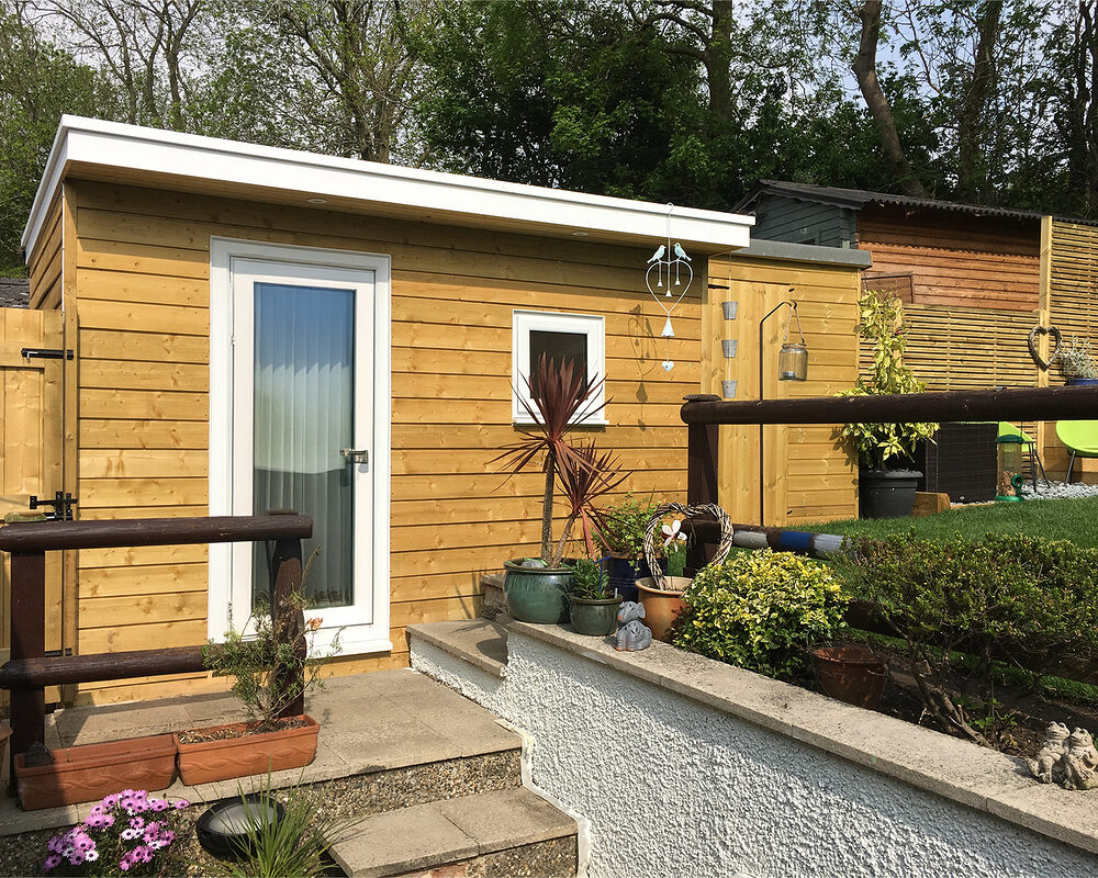 Insulated garden study room with wooden cladding and double UPVC windows built in Tadworth by River.ODP building company.