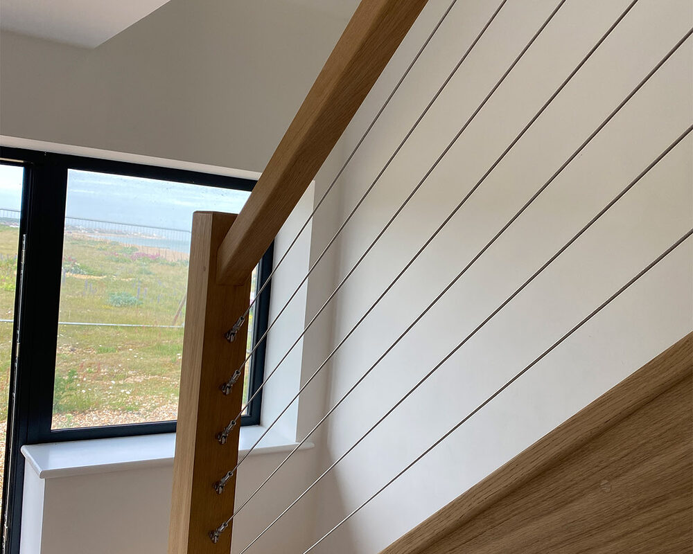 The wooden stairs with premium quality stainless steel wire mounted in balustrade at Beach House in Normans Bay, Eastbourne.
