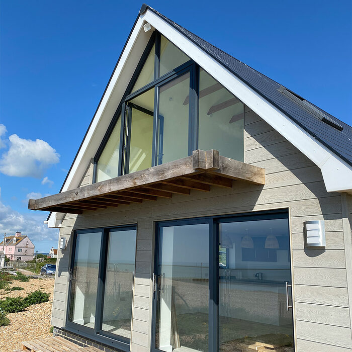 View of the back of the house with modern aluminium sliding patio doors and balcony French doors in Normans Bay in Eastbourne.