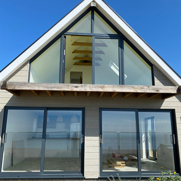 An unusual view of the window adapted to the triangular shape of the attic and two wide sliding doors to the beach.