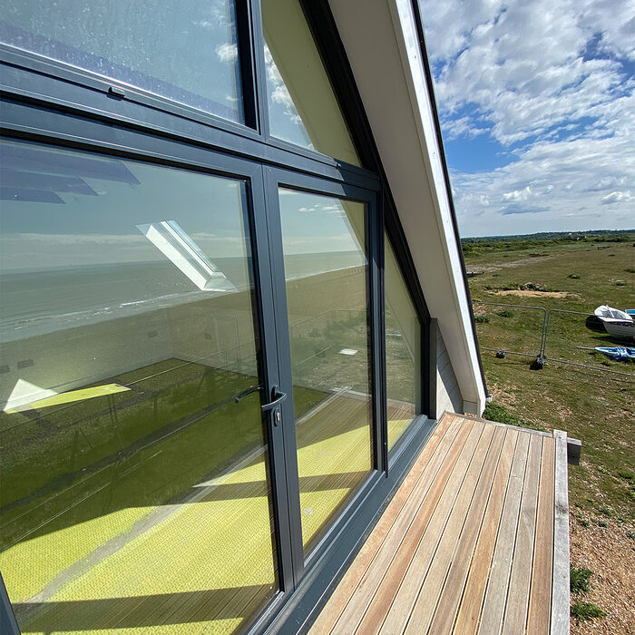 Custom made aluminium anthracite window in a newly built beach house with balcony in Normans Bay, Eastbourne.