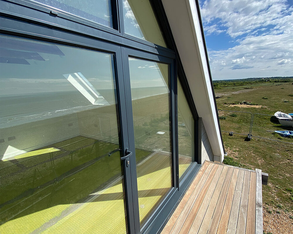 Custom made aluminium anthracite window in a newly built beach house with balcony in Normans Bay, Eastbourne.