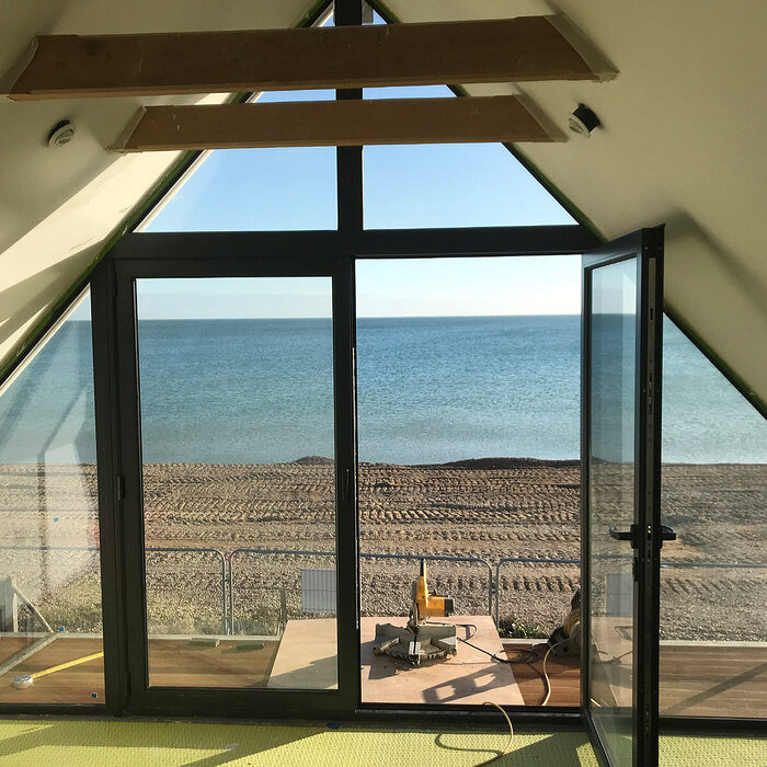 View from inside the attic on a bespoke aluminium black window in a sea view house in Normans Bay, Eastbourne.
