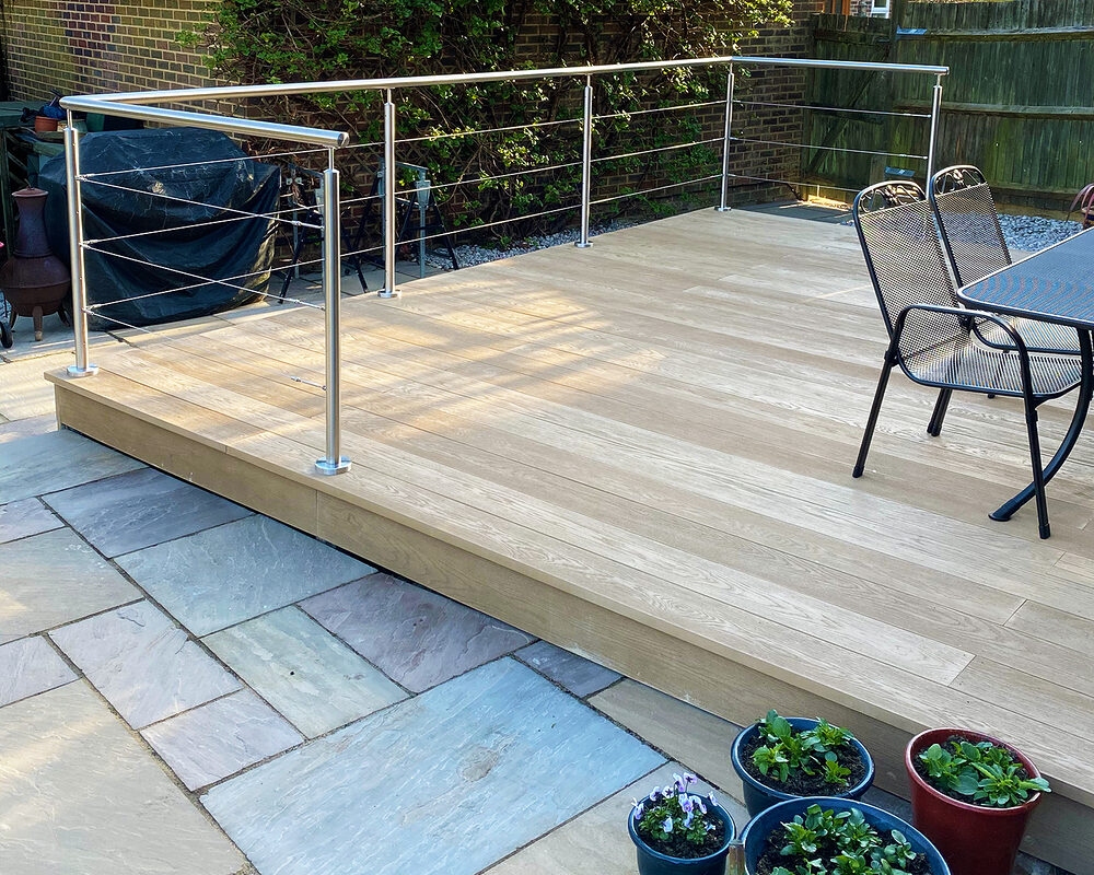 Modern stainless steel balustrade with a wired system installed on composite decking in Horam by Installation company River.ODP.