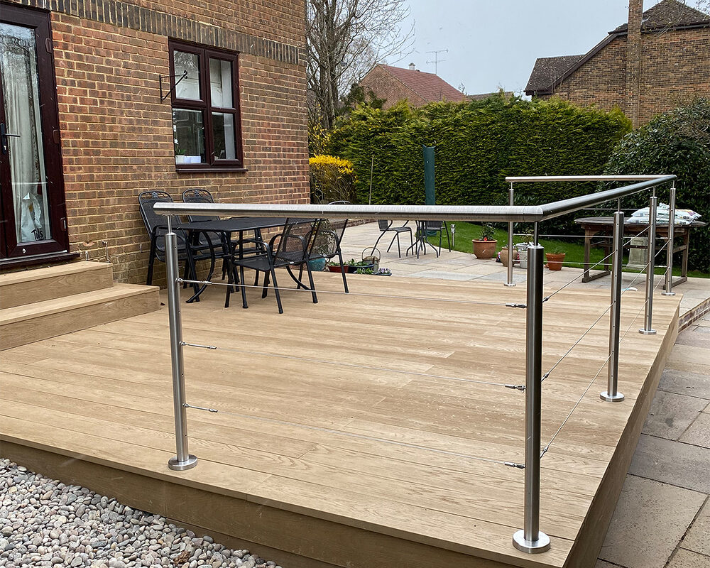 Modern stainless steel balustrade with a wired system installed on composite decking in Forest Row by Installation company River.ODP.