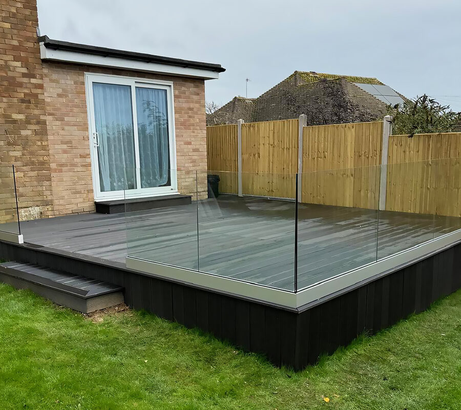 Frameless glass balustrade installed on black composite decking in Farnham by building company River.ODP.
