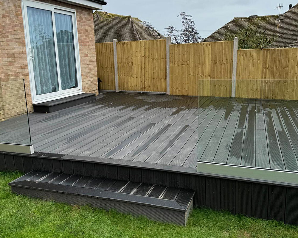 Frameless glass balustrade mounted on black composite decking in Horley by installation company River.ODP.