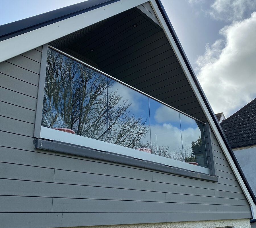 A modern frameless glass balustrade on a balcony with a minimalist design, maximizing the view mounted in Dorking by River.ODP.