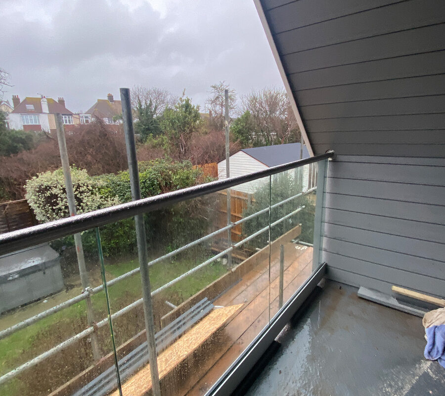 View from balcony with frameless glass balustrade with steel handrail in a minimalist design in Leatherhead installed by River.ODP.