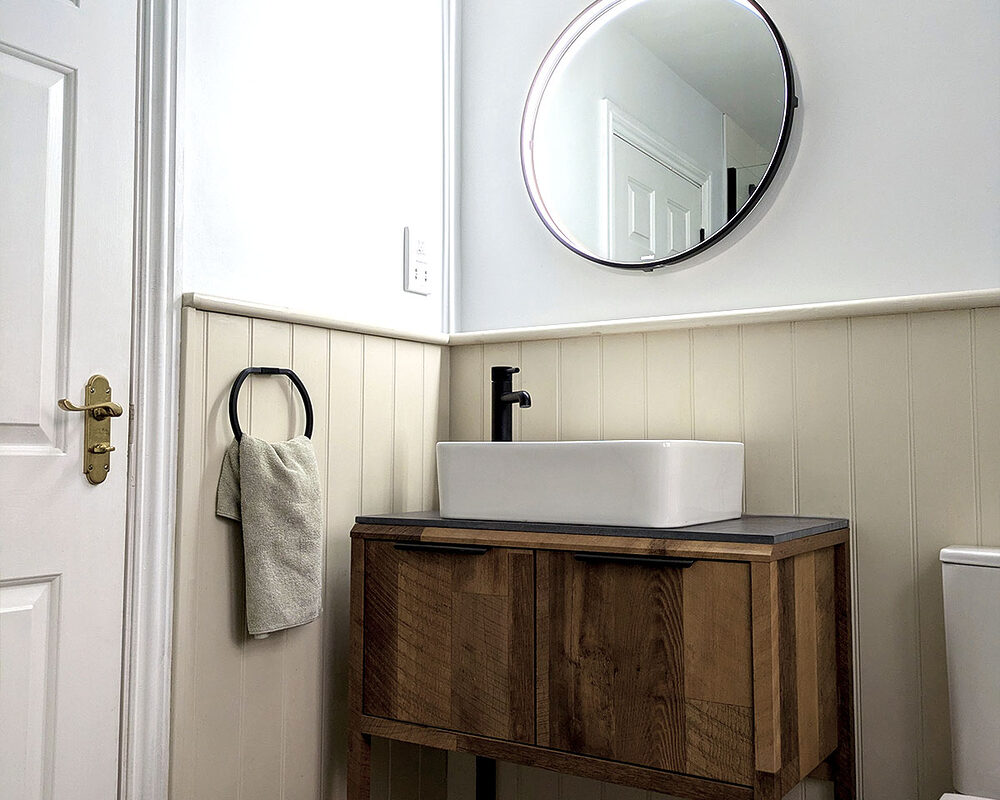 Minimalist bathroom with a wooden vanity and countertop basin.
