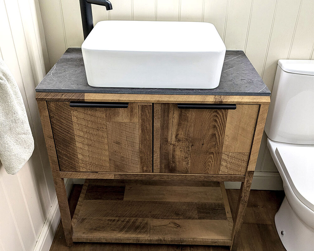 Minimalist bathroom with a wooden vanity, countertop basin, black tap