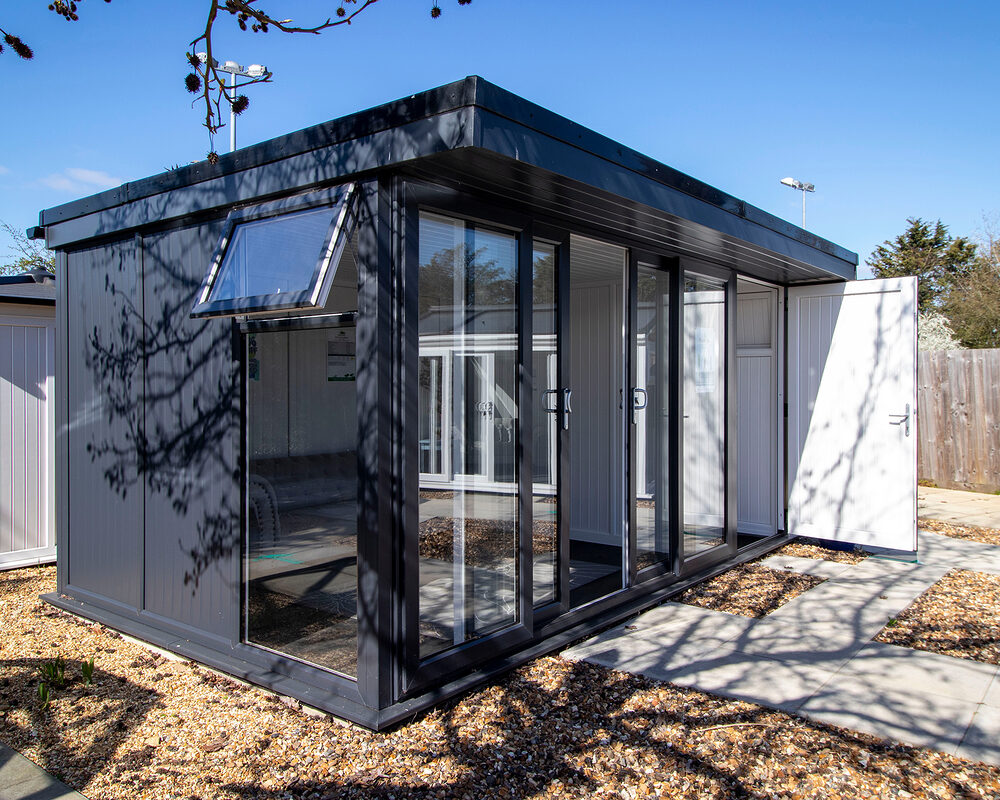 A modern and insulated garden room/study/office in anthracite with a sliding patio doors in West Sussex.