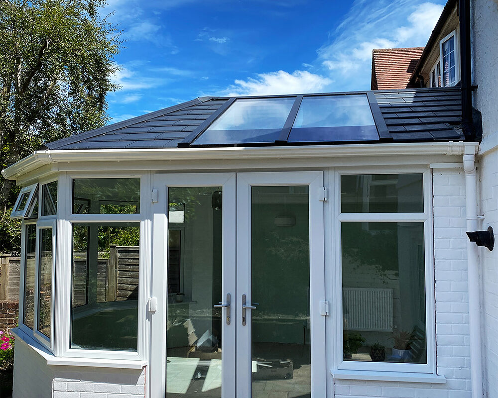 A view on a French doors of a new Victorian conservatory with double glazed windows and warm roof installed by building company River.ODP in Eastbourne, East Sussex.