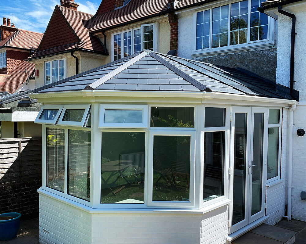 A view from the different angle of a freshly painted new Victorian conservatory with double glazed windows built by River.ODP in East Sussex.