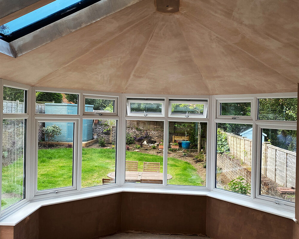 New plaster on the walls and warm roof of a Victorian conservatory with double glazed casement windows in Eastbourne.